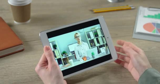 Primer plano de la chica hablando en videoconferencia con una colega sentada en el escritorio en el gabinete. Pantalla de tableta con reunión de negocios en línea entre mujeres empleadas en tableta en interiores. Concepto de trabajo — Vídeos de Stock