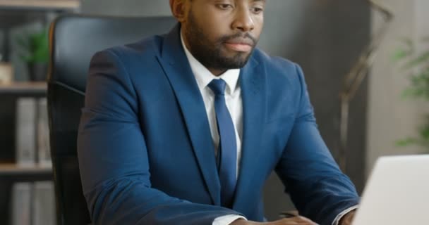 Afroamerikaner beschäftigen männliche Büroangestellte, die am Tisch sitzen und am Laptop arbeiten. Attraktive Geschäftsleute tippen auf der Tastatur. Mann in Anzug und Krawatte im Kabinett. — Stockvideo