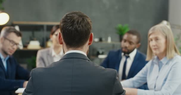 Задняя часть босса-мужчины, сидящего за столом с коллегами по бизнесу компании на встрече и обсуждении работы. Обратный взгляд на кавказца, проводящего конференцию партнеров и инвесторов за столом в офисе. — стоковое видео