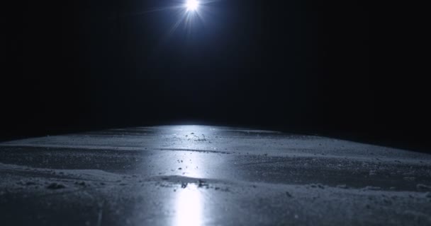 Крупним планом ноги хокеїста або фігуриста на фігуристах ковзають на крижаній поверхні в темряві. Ковзання на льодовій арені у світлі однопроменевої лампи. Концепція матчу хокею . — стокове відео