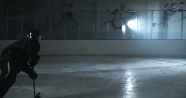 Concept de match de hockey. Joueur de hockey masculin glissant rapidement et frappant la rondelle au but sur la glace. Sportsman patiner et frappe disque avec bâton à la porte sur l'arène glacée. — Video