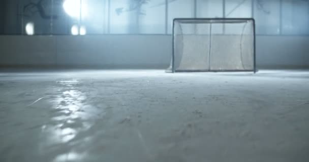Крупним планом вдарив з клубом і забив гол. Камера після ніг хокеїста у фігуристах швидко ковзає на льоду. Спортсмен катається на льодовій арені і кладе диск у ворота з палицею . — стокове відео