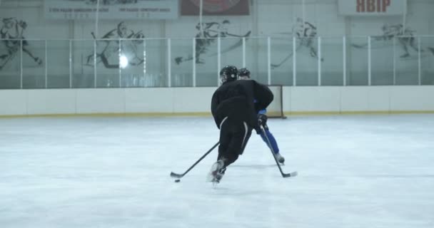 Hockey team speelt wedstrijd op de ijzige arena. Speler slaat puck in poort, maar mist doel. Doelman in poorten op ijs. — Stockvideo