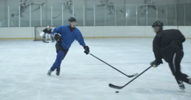 Buz arenasında hokey takımı maç yapıyor. Oyuncular gelecek maçlar için buz üstünde antrenman yapıyor. Oyuncu puck 'a vuruyor ama golü kaçırıyor. Kapıların kalecisi. Savunma ve saldırı konsepti.
