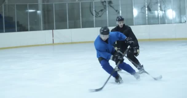 Squadra di hockey giocare partita su arena ghiacciata. I giocatori si allenano per il futuro gioco sul ghiaccio. Giocatore colpire disco nel cancello, ma mancante obiettivo. Portiere cattura disco nei cancelli. Difendere e attaccare il concetto. — Video Stock