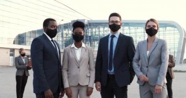 Melez ırk işadamları ve maske takan iş kadınları ve şehir merkezinde dikilen ve kameraya bakan resmî tarzın portresi. Çok ırklı erkek ve kadın iş ortakları Erkek ve kadın iş arkadaşları