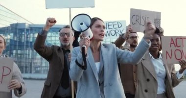 Çok ırklı kalabalıkta işsizliği protesto etmek için megafonla konuşan beyaz bir kadın. Kadın lider grevde konuşma yapıyor ve melez insanlara insan hakları için liderlik ediyor. Vurucu.
