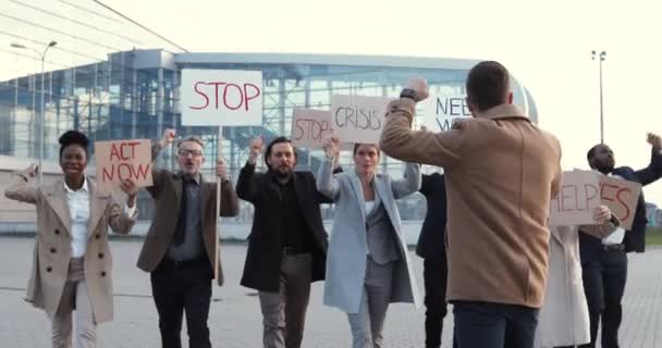 Kaukasischer Mann spricht im Freien per Megafon bei Protesten gegen Arbeitslosigkeit in einer multiethnischen Menschenmenge. Männliche Führungspersönlichkeiten mit Streikreden und Führungspersönlichkeiten gemischter Rassen für Menschenrechte. Protest. — Stockvideo