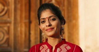 Alnında nokta olan ve geleneksel kıyafetiyle kameraya gülümseyen Hindu genç güzel kadın portresi. Açık havada. Hindistan 'dan gülümseyen mutlu güzel kıza yakın durun..