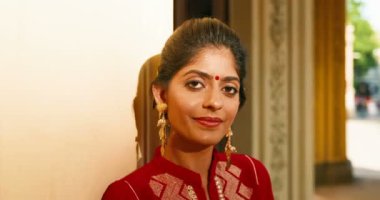 Alnında nokta olan ve geleneksel kıyafetleriyle kameraya neşeyle gülümseyen Hindu genç ve şık bir kadının portresi. Açık havada. Hindistan 'dan gülümseyen mutlu güzel kıza yakın durun..