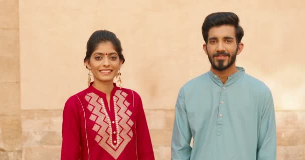 Zdjęcie portretowe szczęśliwej hinduskiej młodej pary mężczyzn i kobiet w tradycyjnych ubraniach stojących na zewnątrz i uśmiechniętych do kamery. Piękna kobieta i przystojny mężczyzna. Koncepcja kulturowa. Styl Indii. — Wideo stockowe