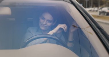 Ön camdan bak. Güzel, genç, beyaz bir kadın direksiyonda oturuyor ve araba sürmeyi öğrendiği için çok neşeli ve kızgın. Çalışmaya devam. Şoförlük yapmaya çalışan iş kadını..