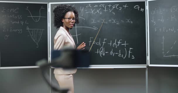 Smartphone recording video virtual lesson at school. Online studying. African American woman teacher explaining math or physics formulas at class on blackboard. Quarantine concept. Pandemic study. — Stock Video