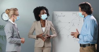 Karışık ırklar, kadınlar ve erkekler, arka planda fizik ya da matematik formülleriyle birlikte sınıfta çalışma kavramını tartışıyorlar. Çok ırklı erkek ve kadınlar ofiste iş büyümesinden bahsediyorlar.