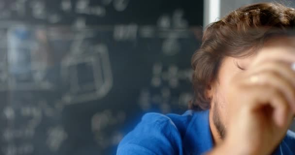 Primer plano hombre caucásico matemático escribir fórmulas y leyes en pantalla transparente en el aula. Pizarra con dígitos y dibujo sobre fondo. Profesor o científico masculino contando y explicando. — Vídeos de Stock