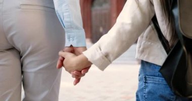 Beyaz bir kadının dışarıda yürürken küçük kızların elini tutarken yakın plan çekimleri. Anne kızlarının elini tutuyor. Sevgi ve ilgi. Aile ilişkileri. Küçük liseli kızla gezen bir kadın..