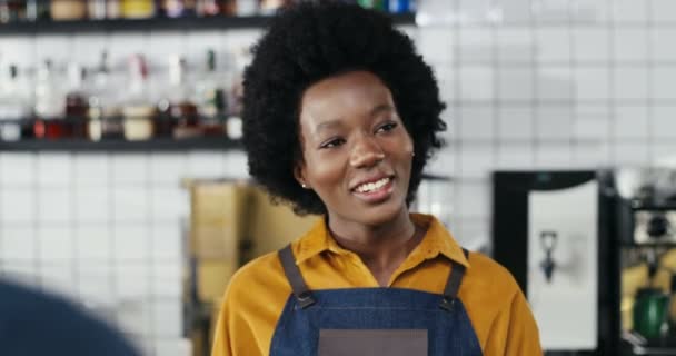Kafkasyalı çiftten sipariş alan gülümseyen Afro-Amerikan bayan barmen. Müşterilerin arkası. Karışık ırklar. Müşteriler kahve alıyor ve kafede garsonla konuşuyor. Çoklu Etnik. — Stok video