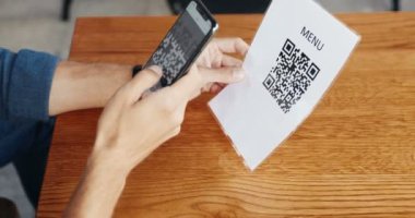Kafedeki müşteriler masada QR kodlarını tararken ve menüleri okurken beyaz erkeklerin elindeki siyah akıllı telefonu kapat. Barda düzen sağlamak için telefon ve teknoloji kullanan bir adam. Salgın konsepti.