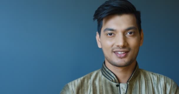 Retrato tiro de belo jovem hindu alegre homem em roupas tradicionais sorrindo para a câmera. Fechar-se de cara feliz atraente rindo alegremente. Interior. — Vídeo de Stock