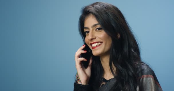Згорніть індуїстську молоду гарну веселу жінку в традиційному одязі, яка радісно розмовляє по мобільному телефону і посміхається. Красуня-індійка говорить по мобільному сміху. Телефонний дзвінок. Розмова. — стокове відео