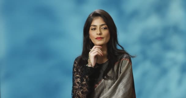 Portrait de jeune femme élégante hindoue en tenue traditionnelle debout devant la caméra et la pensée tout en touchant son menton. Belle femelle considérant quelque chose. — Video