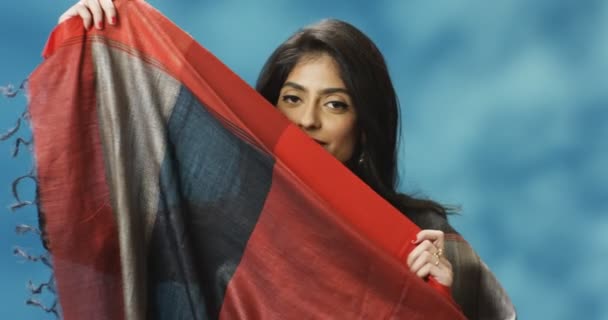 Portrait shot of young Hindu beautiful woman in traditional Indian clothes smiling to camera and closing face with big scarf. Attractive stylish female posing to camera. — Stock Video