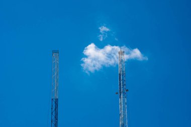 Mavi gökyüzü ve bulutları olan anten kulesi. İletişim konsepti..