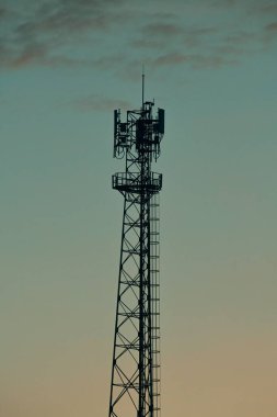 Bulutlu gökyüzünün arkaplanındaki anten kulesi