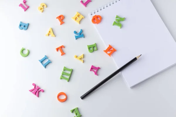 Kladblok met potloden op witte tafel — Stockfoto