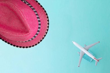 yeşil arka planda oyuncak uçak ve yaz şapkası