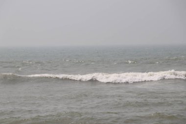 Sahilde dalgalar. Kumlu bir sahilde büyük bir okyanus dalgası