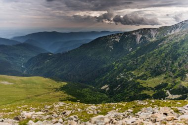 Romanya 'nın Transalpina karayolundan görüldüğü üzere, Parang Romen dağlarındaki yeşil yaz ormanlarının üzerindeki yağmur bulutları Karpatlar' ın en yüksek dağ yolu. 