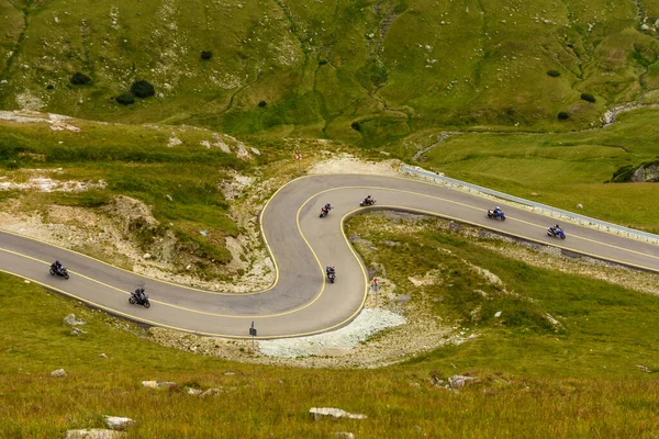 骑自行车的人沿着罗马尼亚的横贯高山公路上美丽的蛇形道路前行 这条公路是喀尔巴阡山脉中位于帕朗山区的最高山路 — 图库照片