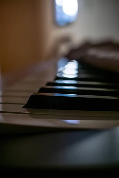 piano keys under a pink cloth with light from a window