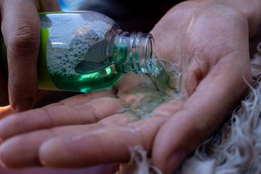 Kız eline şampuan sürüyor.