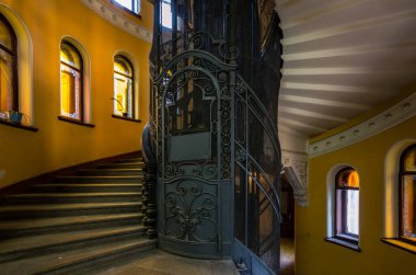 Saint-Petersburg, Rusya, Lomonosova Caddesi 'ndeki tarihi evde spiral merdiven ve klasik metal asansör.