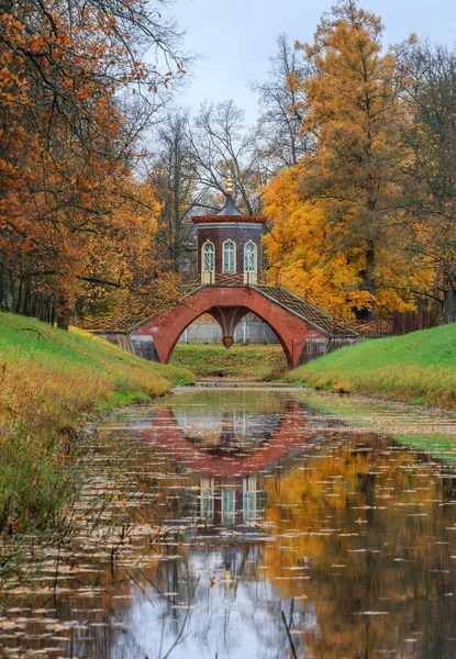 Famous Cross bridge in The Alexander Park during golden autumn, Pushkin city, Saint-Petersburg, Russia, yellow leafs