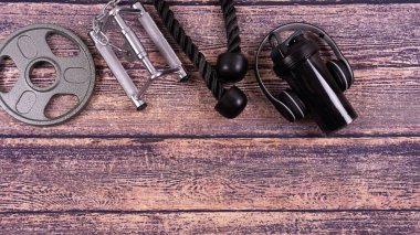 Ahşap arka planda spor aletleri. Mesaj için yer var. Boşluğu kopyala