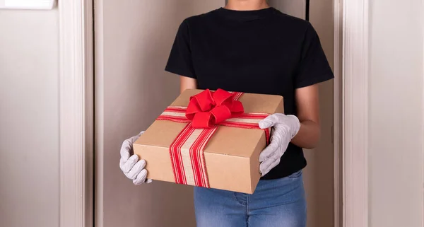 Hands holding box, with rubber gloves Home delivery during virus outbreak, Respecting health standards.