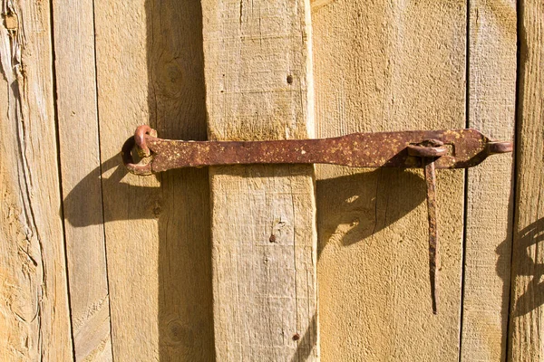 Ahşap kapıdaki geleneksel paslı metal kilidi yakından çek.