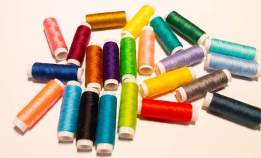 Beyaz arkaplan ve üst görünümde renk dikiş iplikleri