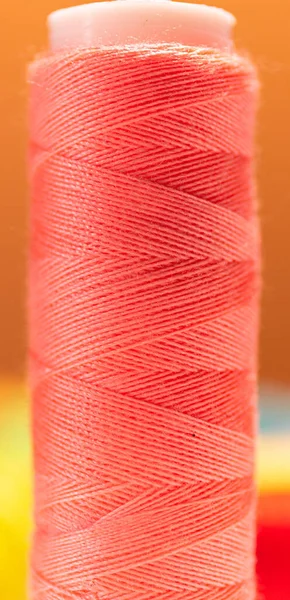 Close up looking of a pink thread reel. Great view of the thread texture