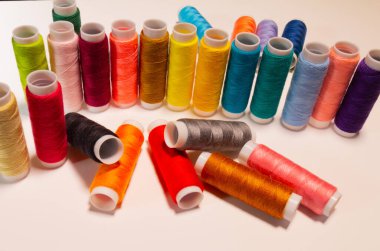 Beyaz arkaplanda birçok renk ipliğinin açı görüntüsü