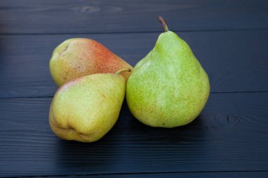 Koyu ahşap arka planda armutlar