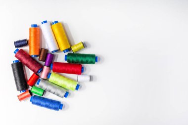 Beyaz arkaplanı dikmek için çok renkli iplikler kümesi