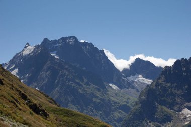 Güzel dağ manzarası, Dombay, Karachay-Çerkessia, dağların zirvelerinden ve parlak mavi gökyüzünden bir manzara.