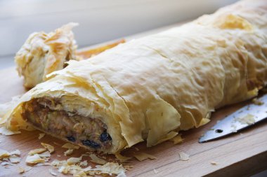 Elma ve kuru üzümle doldurulmuş taze pişmiş börek.