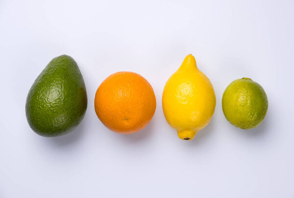 Close up of citrus fruits orange, lemon, avocado and lime isolated on white background.