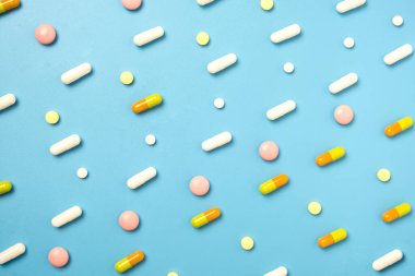 Mavi arkaplanda düzenlenmiş pek çok farklı hapı kapat.