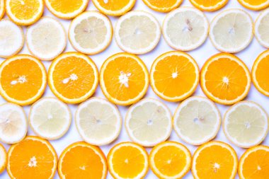 Beyaz arka planda portakal ve limon dilimlerinin düz manzarası vardı..